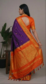 Load image into Gallery viewer, Woman wearing an orange and purple saree with a plant background