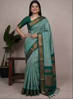 Load image into Gallery viewer, Woman wearing a green saree with a plant in the background