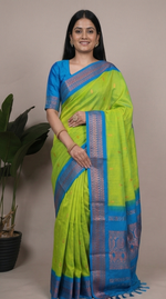 Load image into Gallery viewer, Woman wearing a green and blue saree with a plant background
