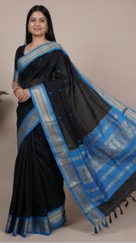 Load image into Gallery viewer, Black saree with blue border worn by a woman, displayed against a neutral background.
