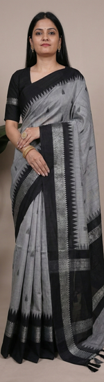 Load image into Gallery viewer, Woman wearing a gray and black saree with a plant in the background
