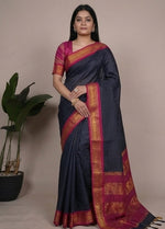 Load image into Gallery viewer, Woman wearing a blue saree with pink and red border, sitting and posing against a neutral background.