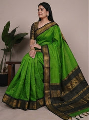 Green saree with black border worn by a model against a neutral background