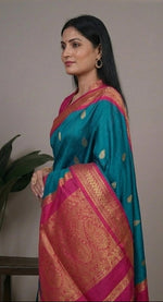 Load image into Gallery viewer, Woman wearing a blue and pink saree with a plant in the background