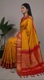 Load image into Gallery viewer, Woman wearing a yellow and red saree with a gray background