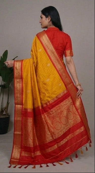 Woman wearing a yellow and red saree with a gray background