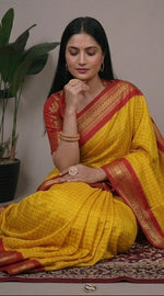 Load image into Gallery viewer, Woman wearing a yellow saree with red border in four different poses.