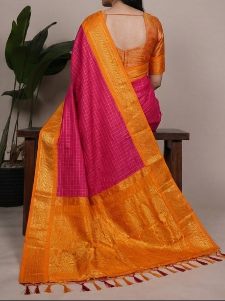 Woman wearing a pink and orange saree with a neutral background