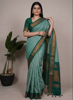 Load image into Gallery viewer, Woman wearing a green saree with a plant in the background