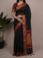 Load image into Gallery viewer, Woman wearing a black saree with a maroon blouse, posing against a neutral background.